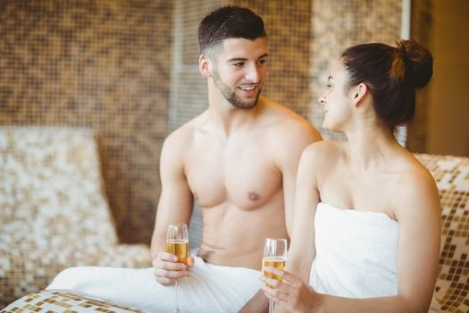 Romantic couple together with champagne glasses at the spa