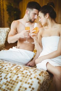 Romantic couple together with champagne glasses at the spa