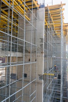 the builder performs work standing on high scaffolding