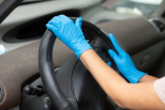 Woman puts on protective rubber gloves and driving a car