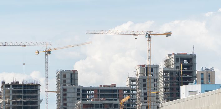 Construction site with cranes on the background of the day sky