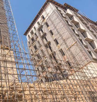 reinforcement for pouring concrete on the building background. marble finishing works on the facade of a high building