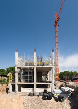 construction crane and a concrete structure of the building on a background the sky