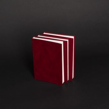 books with red cover on black background, isolated. back to school