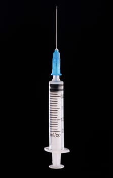 one medical syringe in an upright position on a dark blue background