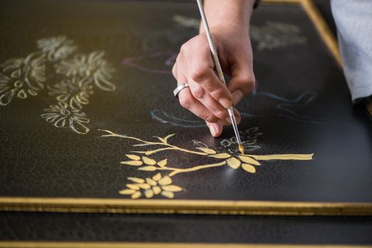 painter decorator draws a pattern of tree and leaves