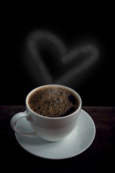 Cup of coffee with heart shape smoke on old wooden table