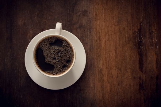 Cup of coffee on wooden background. Copy space. Top view. Flat lay