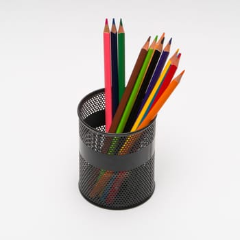 set of colored pencils in a basket on a white background, isolated. back to school