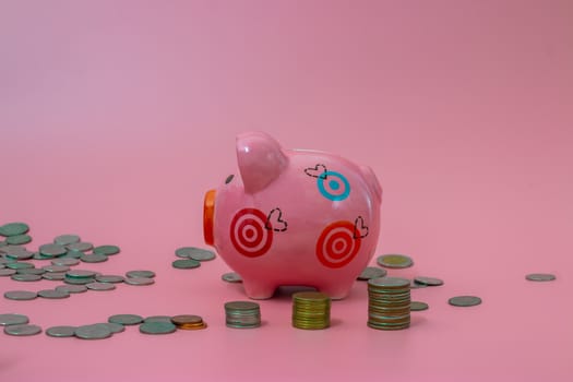 Pink piggy bank and coins on pastel pink background, Financial concepts