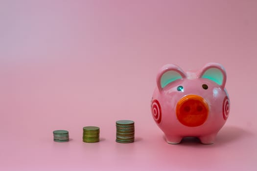 Pink piggy bank and coins on pastel pink background, Financial concepts