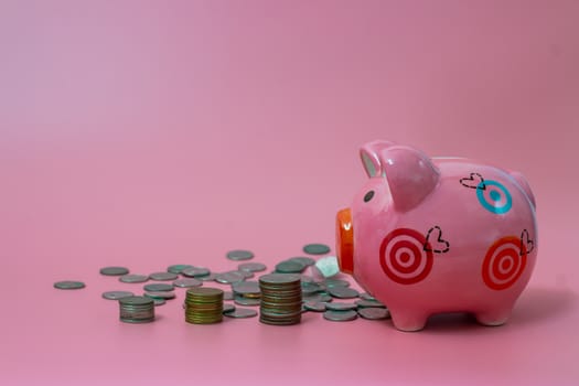 Pink piggy bank and coins on pastel pink background, Financial concepts