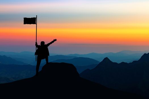 Concept of success, Silhouette of business man with a victory flag on the top of the mountain