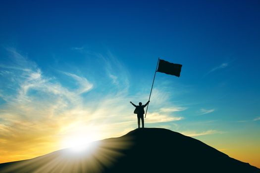 Concept of success, Silhouette of business man with a victory flag on the top of the mountain