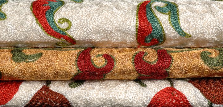 folded three roll Eastern and Asian textiles embroidered with gold color