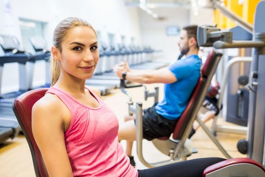 Fit people using weights machines at the gym