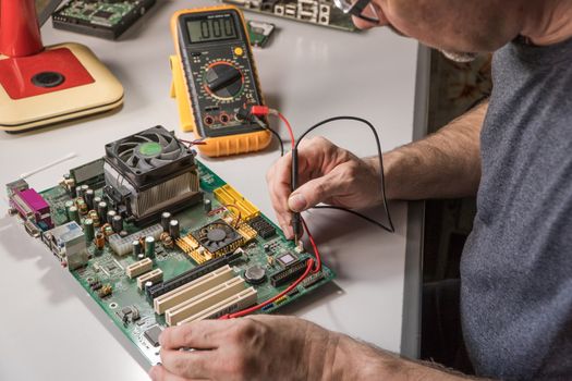 electronics technician is testing a computer chip. PC repair
