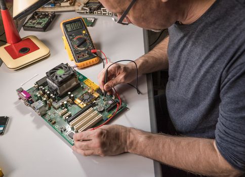 electronics technician is testing a computer chip. PC repair