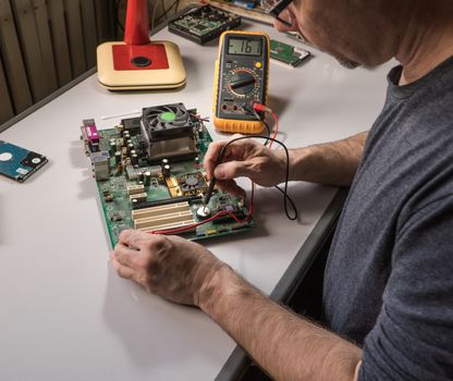 electronics technician is testing a computer chip. PC repair