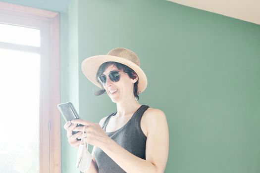 Woman in striped shirt and straw hat using mobile phone