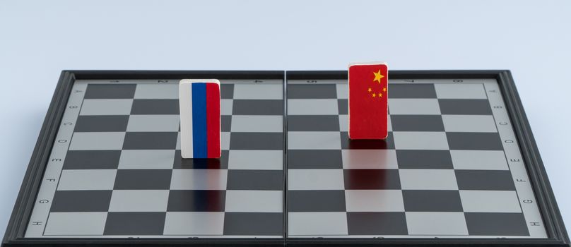 Symbols flag of Russia and China on the chessboard. The concept of political game.