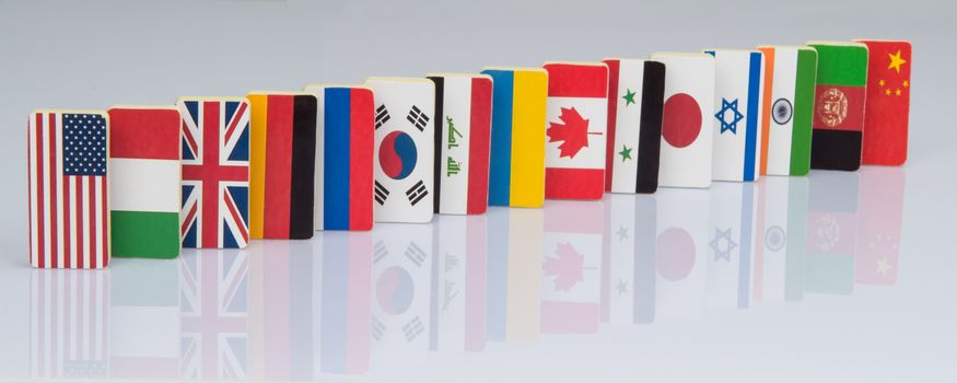 The domino effect with tiles of flags of different countries of the world. conceptual photo, political games. Studio shooting