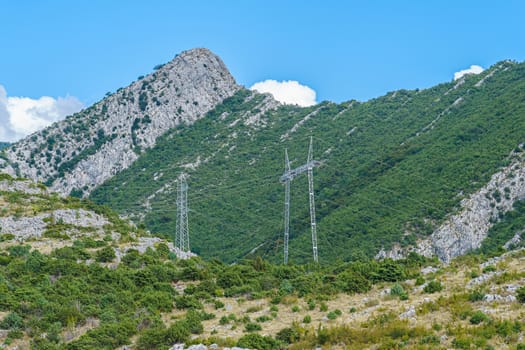 peaks and slopes of mountains covered with vegetation against a blue sky with clouds