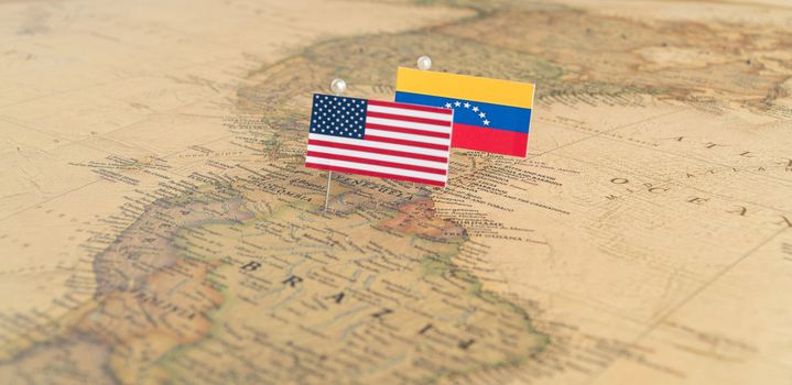 Flags of the USA and Venezuela on the world map. Conceptual photo, politics and world order