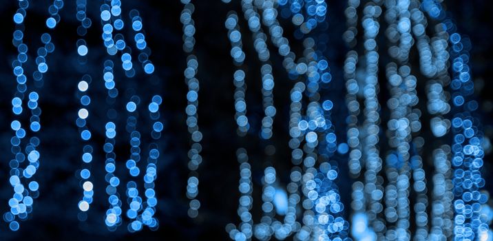 abstract blurred background with round blue bokeh on a black background, christmas garlands