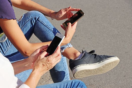 Two young girls watching smart mobile phones