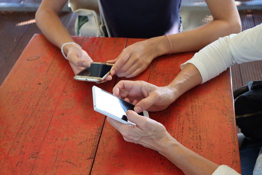 Two young girls watching smart mobile phones