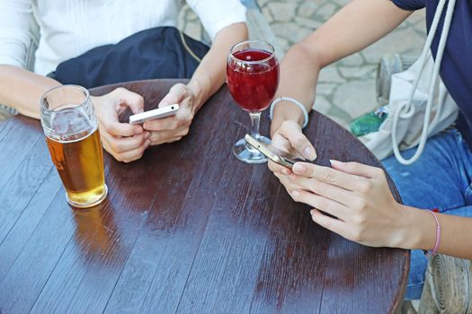 Two young girls watching smart mobile phones