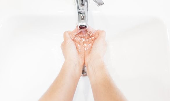 Man washing his hands hygienically with soap under the tap