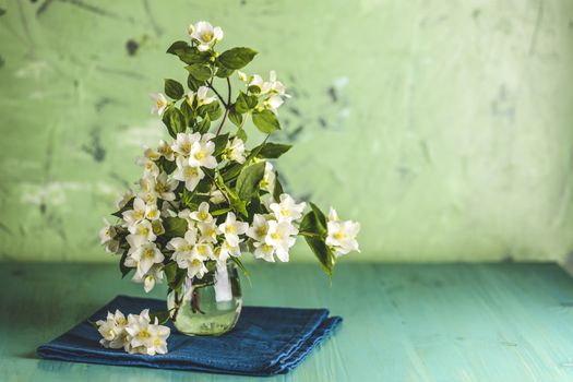 Beautiful jasmine bouquet on light green wooden surface table. Holiday greeting card with copy spice for you text.