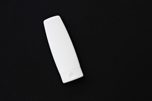 Blank label cosmetic container bottle as product mockup on black background, hygiene and healthcare