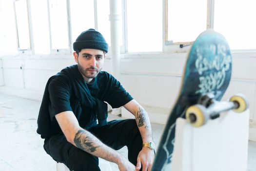 Portrait of relaxed young fashionable skater man in black outfit