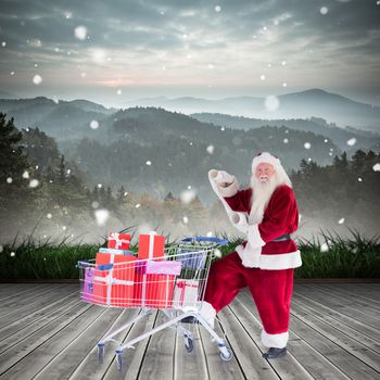 Santa delivering gifts from cart against mountain range beyond wooden floor