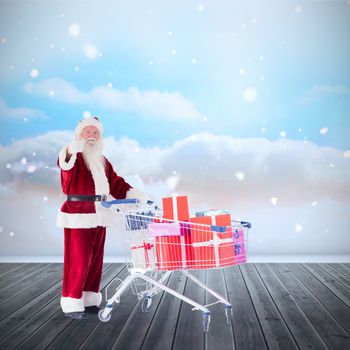 Santa pushing a shopping cart against clouds in a room