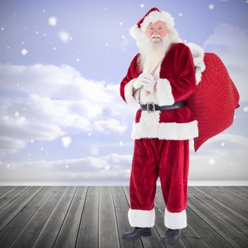 Santa smiling at camera against clouds in a room
