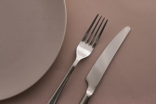 Empty plate and cutlery as mockup set on brown background, top tableware for chef table decor and menu branding design