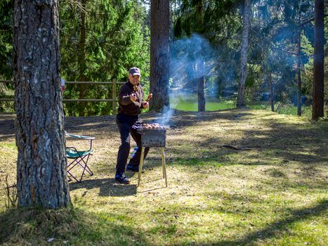 Red hot burning charcoal preparing for grilling, barbecue grill, BBQ. Forest on the background. Waiting for the placement of your food. Close up. vacation concept