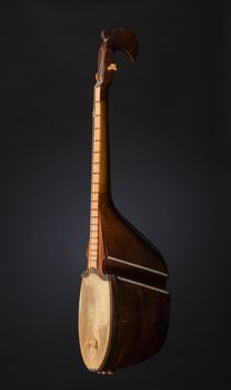 ancient Asian stringed musical instrument on black background with backlight