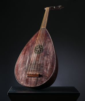 ancient Asian stringed musical instrument on black background with backlight