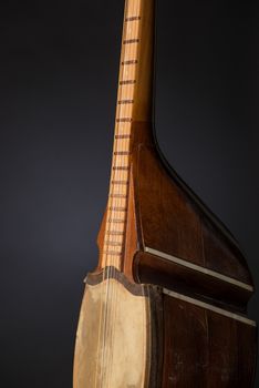 part ancient Asian stringed musical instrument on black background with backlight