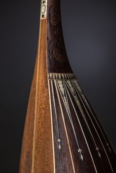 part ancient Asian stringed musical instrument on black background with backlight