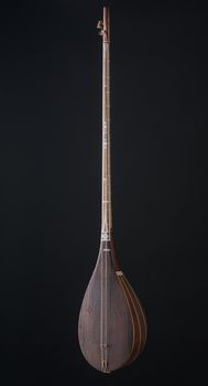 ancient Asian stringed musical instrument on black background with backlight