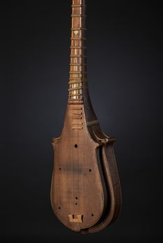part ancient Asian stringed musical instrument on black background with backlight