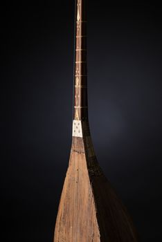 part ancient Asian stringed musical instrument on black background with backlight