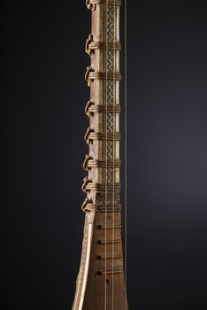 ancient Asian stringed musical instrument on black background with backlight. tuning peg