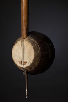 part ancient Asian stringed musical instrument on black background with backlight